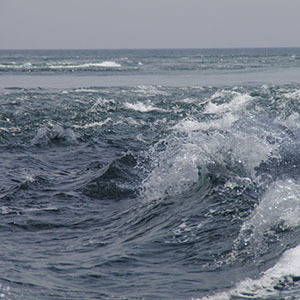 In Naruto, Japan, a boundary between different water masses appears as a sliver of still water beyond turbulent waters.