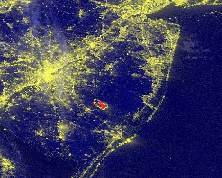 This image shows a combination of nighttime lights and active fire imagery for the Mullica River Fire, New Jersey on June 20, 2022.