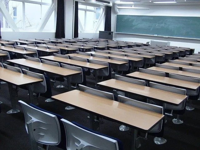 A classroom full of empty desks and chairs.