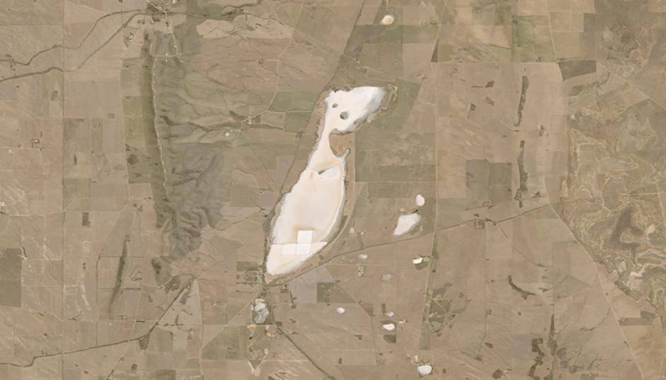 Lago de arena rosada en medio del paisaje marrón