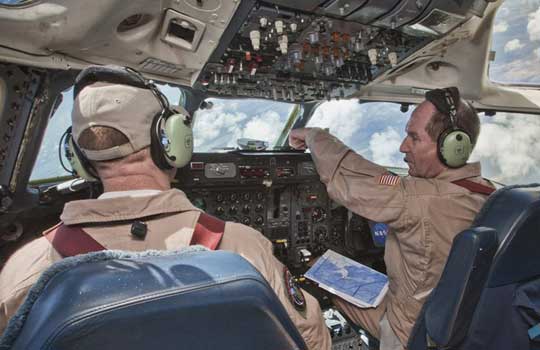 Photograph of pilots flying a DC-8 aircraft during Hurricane Karl