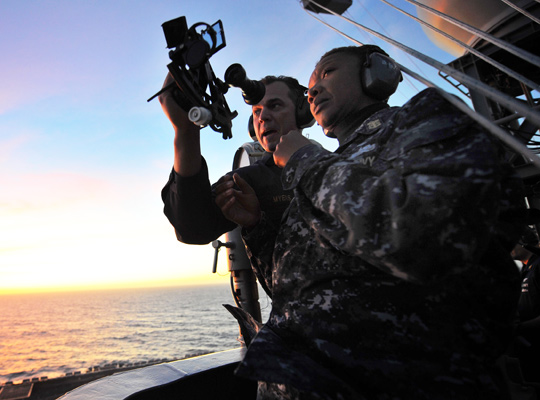 Photograph of a Navy officer training a colleague on how to use a sextant