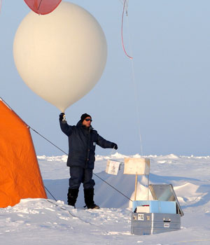 Photograph of a researcher launching an ozonesonde balloon in the Arctic