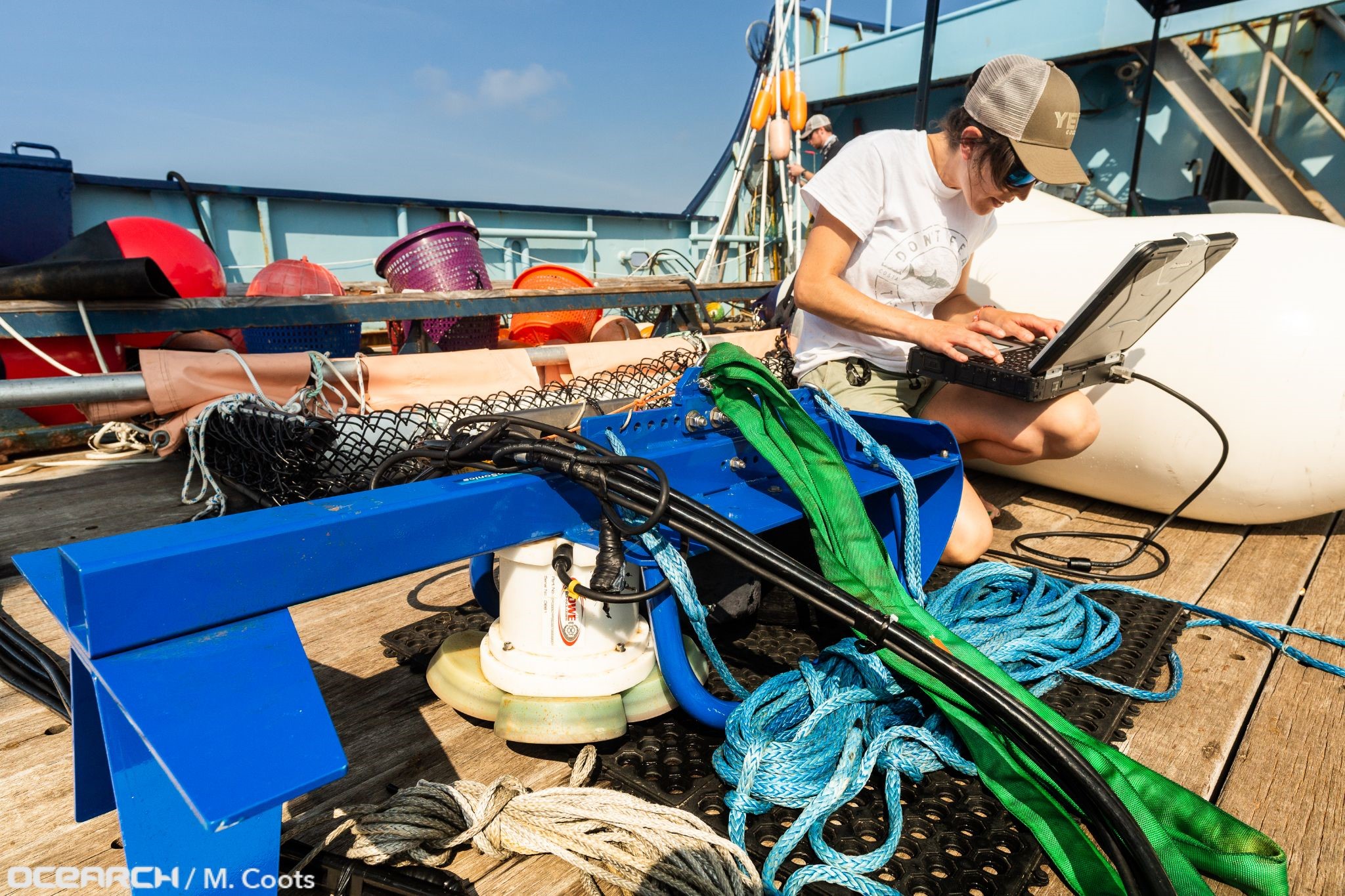 Kyla Drushka connects with the Acoustic Doppler Current Profiler before deploying it over the side of the research vessel OCEARCH.