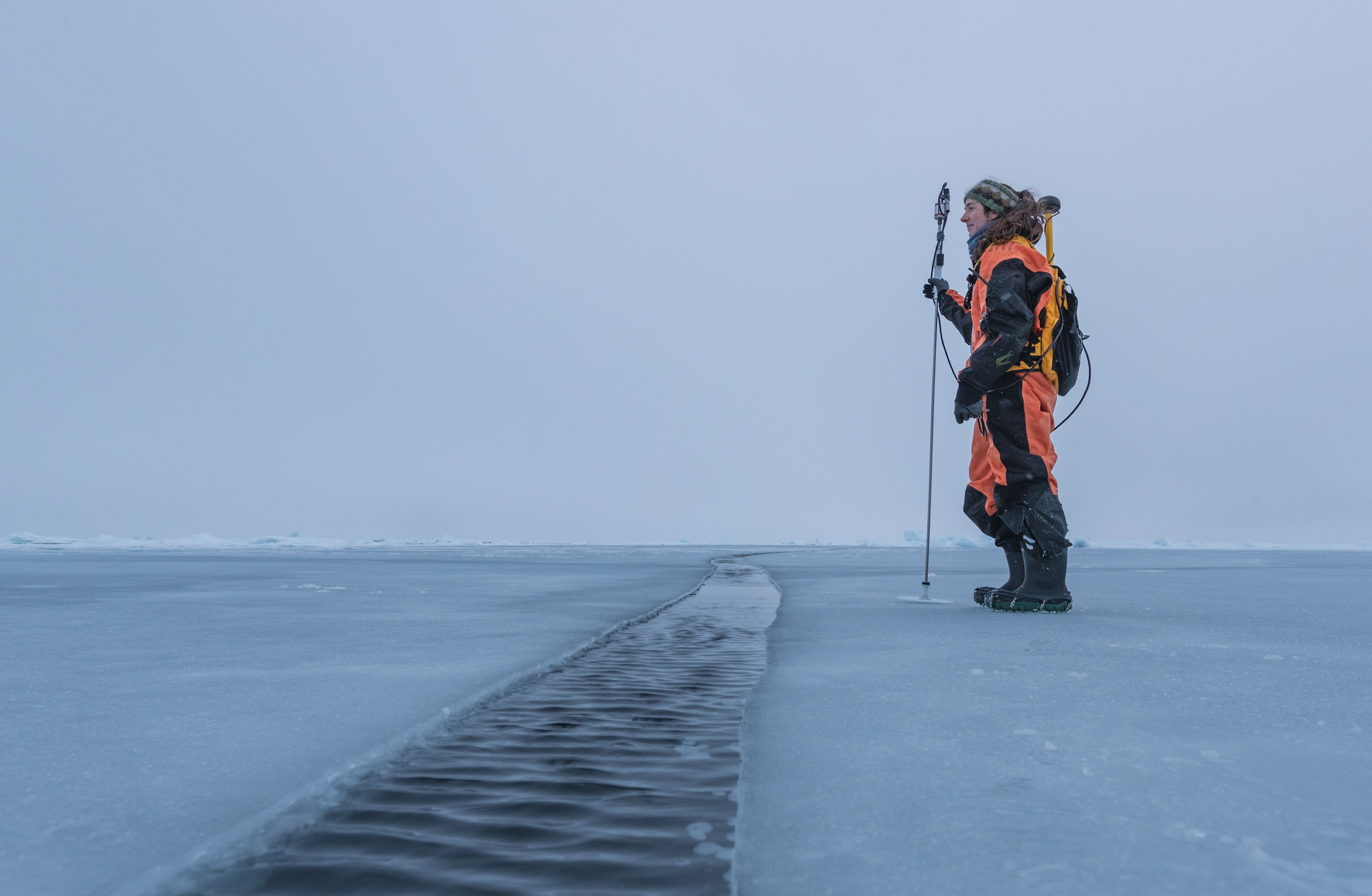 Dr. Melinda Webster stands on young sea ice in the Arctic