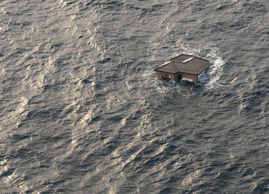 Photograph of a house drifting in the Ocean after an earthquake and tsunami in Japan