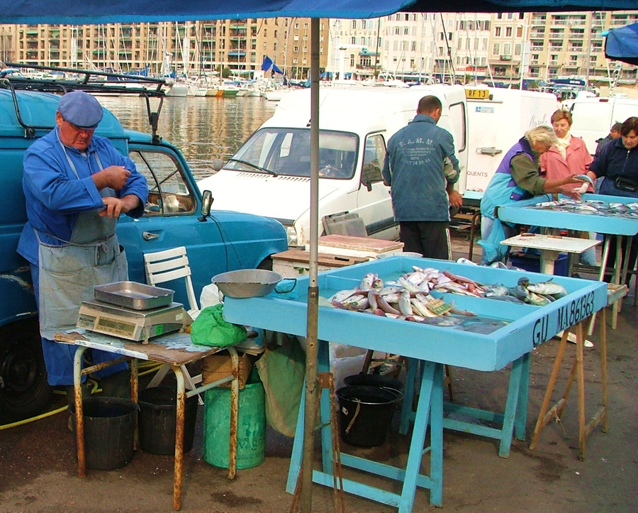 Photograph of fishmongers at a pier in France