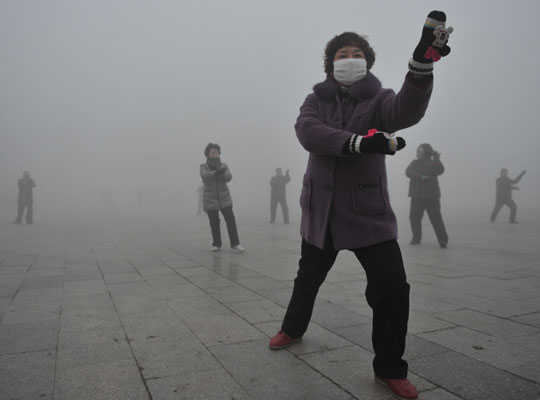 Photograph of retirees performing tai chi during a smoggy day in China