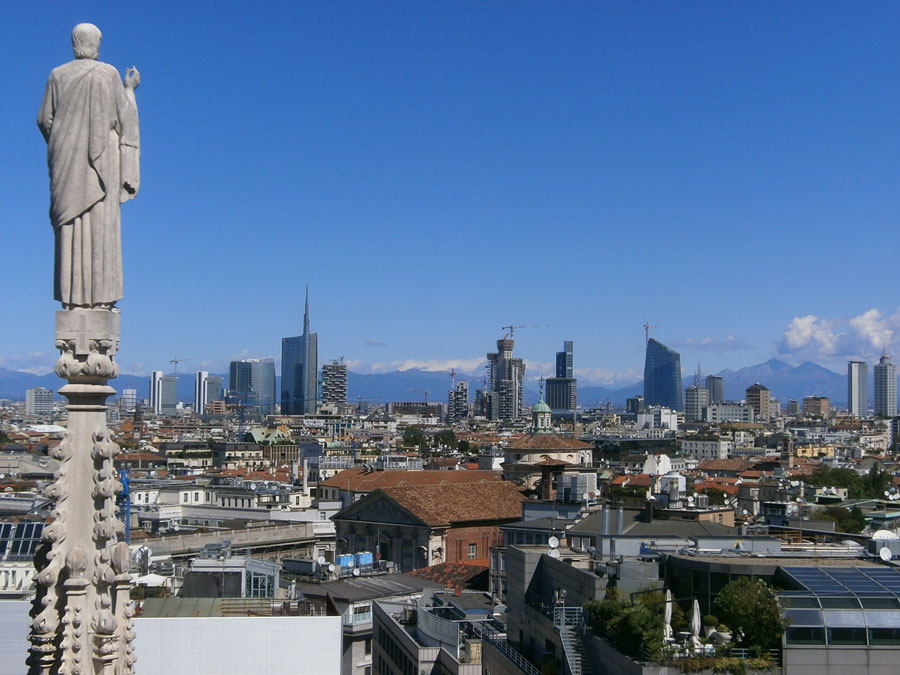 Photograph of a cathedral spire against a backdrop of the Milan skyline