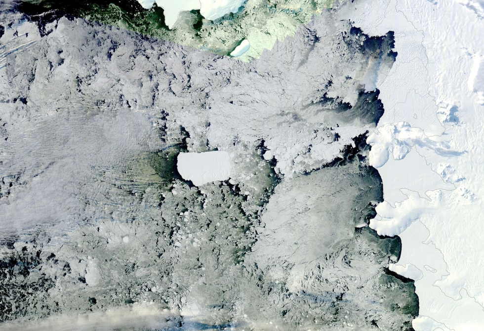 This NASA Terra Moderate Resolution Imaging Spectroradiometer (MODIS) image shows This image from the Moderate Resolution Imaging Spectroradiometer (MODIS) instrument aboard NASA’s Terra satellite shows B-22A–the largest piece of Antarctica’s B-22 iceberg–moving out to sea on  March 26, 2023. The massive B-22 iceberg measures more than 3,000 square kilometers and has only moved 60 miles from its birthplace, the floating ice tongue of Antarctica’s Thwaites Glacier, in the past two decades.