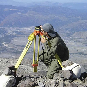 A researcher checks the calibration of a ground-mounted Global Positioning System (GPS) station on Mount St. Helens. 