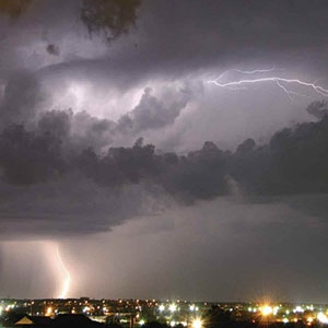 Photograph of a thunderstorm discharging electricity as both cloud flashes and ground flashes.