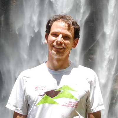 Photograph of Dr. Larry O'Neill in front of a waterfall