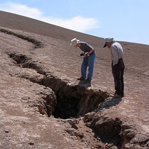 Researchers Matthew Pritchard and Gabriel Gonzalez examine a large crack caused by an earthquake in the Atacama Desert of northern Chile.