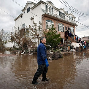 Person walking through flooded streets after Hurricane Sandy