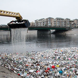 After a rainstorm, a loader removes trash with high concentrations of plastic at the mouth of the Los Angeles River in Long Beach, California.
