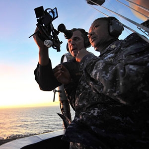 U.S. Navy officer Jonathan Myers explains to his colleague April Beldo how to use a marine sextant during a demonstration of celestial navigation.