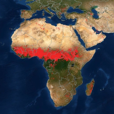 This color map shows Africa, portions of the Middle East, and Southern Europe. The Northern third of Africa is colored in shades of tan to highlight the desert regions. The middle of Africa is covered in red dots to indicate where fires have been detected. The Southern portion of Africa is green to reflect the more humid, vegetation-rich areas.