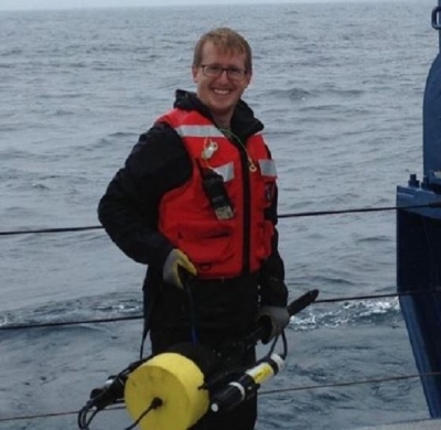 Wearing a wet suit and a life vest, Dr. James Allen poses for a photo on the deck of a ship in the North Atlantic prior to dropping a sensor into the water.