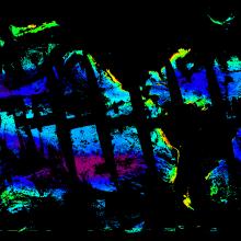 This is an image showing simulated chlorophyll concentrations in the ocean on March 21, 2022. The image has a black background. Regions colored in blue represent areas of low chlorophyll concentration, green are medium, and red areas have high levels. The image has strips of black running through the colored areas from the upper left to the lower right to show PACE’s orbital track around the globe and places across the ocean where it has not scanned.