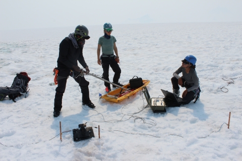 Three scientists conducting research on an ice sheet