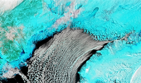 False color image with land and ice appearing as teal and clouds in white.
