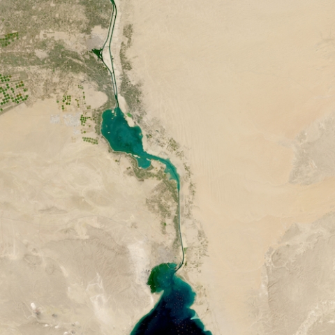 Image of desert with a large lake at the bottom; canal with water leading north with agricultural fields beside lake/canal.