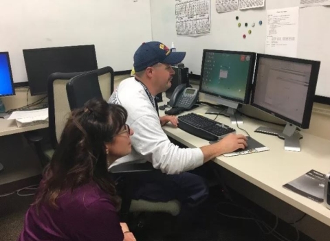 Lori Schultz trains a member of the Search and Rescue team on integrating Geospatial Information Systems (GIS) data products into their workflow. 