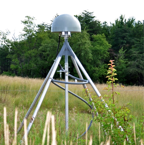 This image shows a four-legged GNSS antenna under a protective dome atop a deeply-anchored geodetic monument to reduce spurious local ground motions.