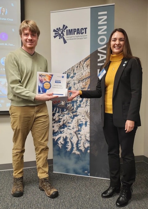 Cerese Albers presents Christopher Phillips with an IMPACT Award while standing in front of an IMPACT Innovate banner