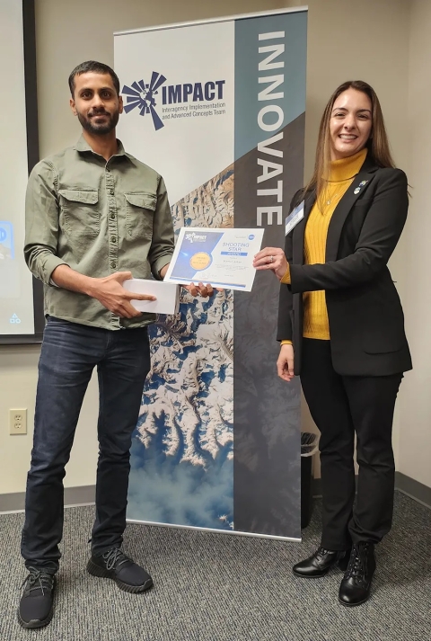 Cerese Albers presents Kumar Ankur with an IMPACT Award while standing in front of an IMPACT Innovate banner