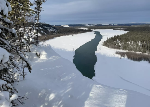 outdoor image of open river water surrounded by white snow and ice