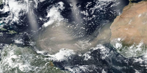 True color image showing a large brown cloud of dust extending from the east coast of Africa across the Atlantic Ocean.