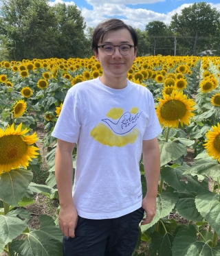 Photo of Dr. Jida Wang in field of sunflowers