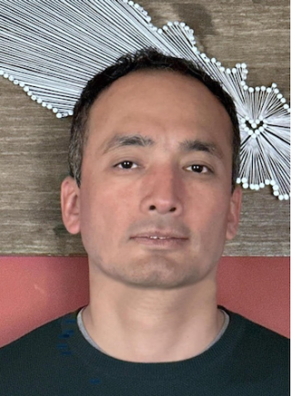 Indoor headshot of Dr. Manil Maskey standing in front of a wall