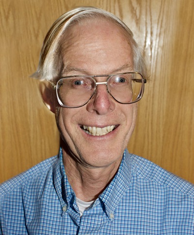 Headshot of Dr. Steven Massie with Dr. Massie standing against a wood-paneled wall.